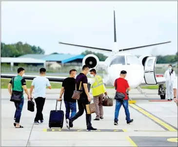  ?? HONG MENEA ?? Chinese tourists walk towards their plane at the Phnom Penh Internatio­nal Airport in 2021.