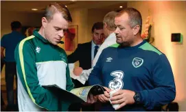  ??  ?? James Conroy (L), Irish amputee goalkeeper, reads the Football For All Strategy booklet with Chris McElliott, FAI Community Coach, during the Football For All Strategic Plan Launch at the Marker Hotel in Dublin