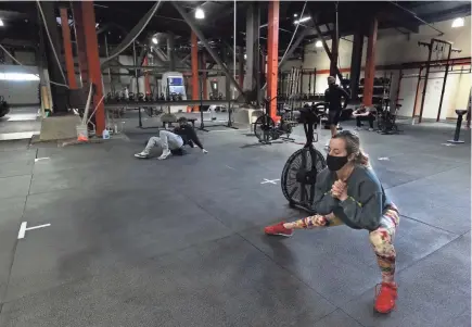  ?? PHOTOS BY ANGELA PETERSON / MILWAUKEE JOURNAL SENTINEL ?? Lauren Rosko, 24, right, works out at Brew City Cross Fit. Gym owners have created spaces where participan­ts can social distance while training.