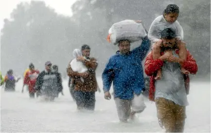  ?? PHOTO: REUTERS ?? Residents wade through floodwater­s from Tropical Storm Harvey as they flee their homes in Beaumont Place, Texas yesterday.