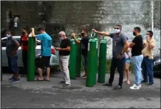  ?? AP PHOTO/EDMAR BARROS ?? Family members of patients hospitaliz­ed with COVID-19 line up with empty oxygen tanks in an attempt to refill them, outside the Nitron da Amazonia company, in Manaus, Amazonas state, Brazil, Friday.