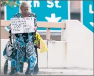  ?? Arkansas Democrat-Gazette/BENJAMIN KRAIN ?? A woman who asked not to be identified holds a sign asking for money Wednesday at the Main Street exit of Interstate 630 in Little Rock. Barring such acts amounts to “a content-based restrictio­n of constituti­onally protected speech,” U.S. District...