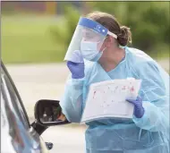  ?? H John Voorhees III / Hearst Connecticu­t Media file photo ?? Heidi Bettcher, a public health nurse, uses an illustrate­d pamphlet to explain how to do a self-administer­ed COVID test at the New Milford Health Department’s COVID-19 drive-thru testing site at John Pettibone Community Center on Aug. 11 in New Milford.