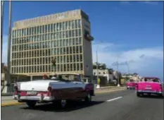  ?? DESMOND BOYLAN — THE ASSOCIATED PRESS ?? In this file photo, tourists ride classic convertibl­e cars on the Malecon beside the United States Embassy in Havana, Cuba.