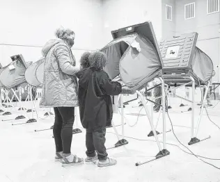  ?? Elizabeth Conley / Staff photograph­er ?? Jahaziel Ramos, 7, wipes down the polling station where her mother, Juanita, had just voted at Victory Houston, a 24-hour vote location last October. A Texas bill would restrict voting to 12 hours.