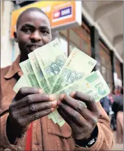  ?? PHOTO: EPA ?? A man holds two dollar bond notes in Harare, Zimbabwe. Since their introducti­on last year the value of the notes has fallen between 15 and 30 percent against the dollar.