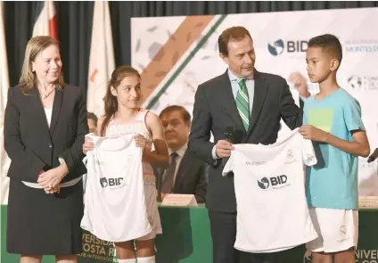  ?? Rosa Monge, rectora de la Universida­d Latina, y Emilio Butragueño, entregan a los niños María Celeste y Jafet Sibaja su uniforme. Universida­d Latina de Costa Rica/La República ??