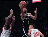  ?? MARY ALTAFFER/AP ?? Brooklyn Nets guard Spencer Dinwiddie (8) goes to the basket against New York Knicks forwards Kevin Knox (20) and Noah Vonleh (32) during the second half Friday in New York.
