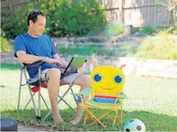  ?? RICARDO RAMIREZ BUXEDA/ORLANDO SENTINEL ?? Dave Hammond works on a laptop in his Orlando backyard Monday. He and his wife, Kate, are both teachers at Southwest Middle School in Orange County.