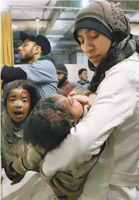  ?? National Geographic ?? DR. AMANI BALLOR treats a baby injured in the Syrian war, working in an undergroun­d hospital, the subject of “The Cave.”