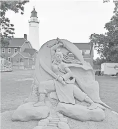  ?? THE SAND LOVERS ?? Sculpted wonders rise against the backdrop of the Fort Gratiot Lighthouse at the Blue Water SandFest in Port Huron, Mich.