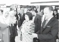  ??  ?? CHRISTINA melawat tapak pameran dan menerima penjelasan daripada ketua pasukan yang menyertai pertanding­an itu.