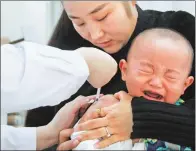  ?? LI CHUNHUI / CHINA NEWS SERVICE ?? A child receives EV 71 vaccine for hand, foot and mouth disease in Huaibei, Anhui province, in January.