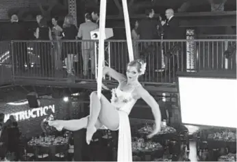  ?? Photos by Joanne Davidson, Special to The Denver Post ?? An aerialist, performing without a net, was a focus of attention during the social hour that preceded dinner.