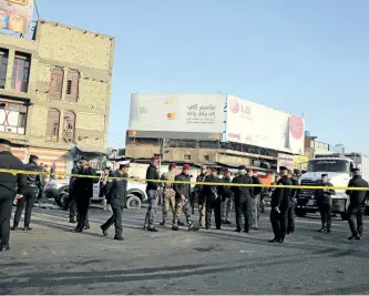  ?? SABAH ARAR/GETTY IMAGES ?? Iraqi security forces cordon off the area where a double suicide bombing killed at least 38 people in central Baghdad on Monday, the second such attack in the Iraqi capital in three days.