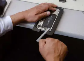  ?? Ulysses Ortega, © The New York Times Co. ?? Shakeel Taiyab, an independen­t repair technician, replaces the battery on an iphone 12 using Apple’s certified repair equipment in San Francisco on May 19.