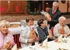  ?? RP-FOTO: JÜRGEN LAASER ?? VdK-Ortsvorsit­zender Heinz Maaßen verteilt Weckmänner an die rund 130 Gäste der VdK-Feier im Saal Sodekamp-Dohmen.