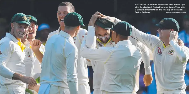  ?? Picture: AFP/SAEED KHAN ?? STATEMENT OF INTENT: Teammates mob Nathan Lyon after he dismissed England batsman James Vince with a pinpoint throwdown on the first day of the Ashes Test in Brisbane.