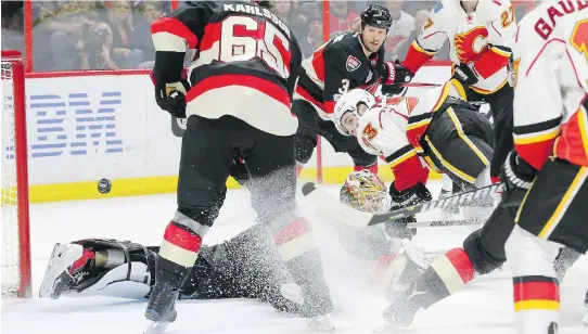 ?? JULIE OLIVER ?? Calgary’s Sean Monahan watches the puck get past Senators goalie Mike Condon to give Calgary a 2-0 lead. Ottawa came back to tie it, but the Flames won in overtime.