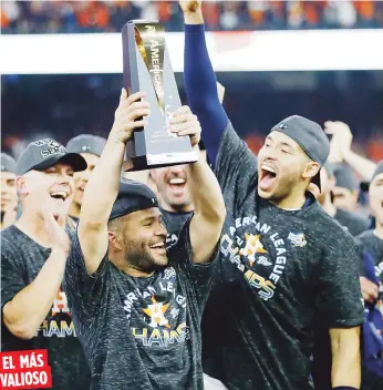  ?? AP / Matt Slocum ?? EL MÁS VALIOSO José Altuve levanta el trofeo de Jugador Más Valioso de la Serie de Campeonato mientras lo miran el dirigente AJ Hinch, izquierda, y Carlos Correa.