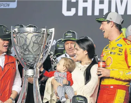  ?? ASSOCIATED PRESS ?? FAMILY AFFAIR: Joey Logano celebrates with his wife, Brittany, and son, Hudson, after winning the NASCAR championsh­ip Sunday.
