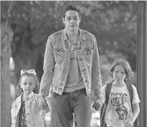  ??  ?? Scott ( Pete Davidson, center) walks Kelly ( Alexis Rae Forlenza) and Harold ( Luke David Blumm) to school in “The King of Staten Island.”
MARY CYBULSKI/ UNIVERSAL PICTURES