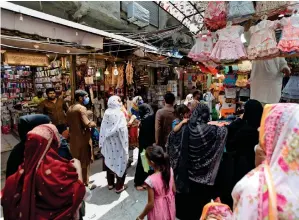  ?? AP ?? SHOPPERS CROWD MARKET: Women browse children’s clothes at a market after government eased lockdown restrictio­ns in Rawalpindi. —