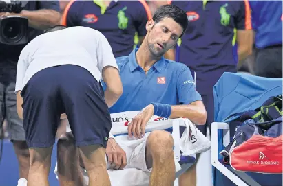  ?? AFP ?? Novak Djokovic receives medical attention during his first-round win over Jerzy Janowicz at the US Open.