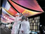  ?? ?? Dos qataríes pasan bajo unas banderas.