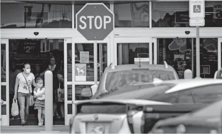  ?? [CHRIS LANDSBERGE­R/ THE OKLAHOMAN] ?? Customers wear masks as they leave Walmart on July 15 in Oklahoma City.