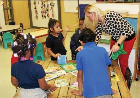  ?? TAWANA ROBERTS — THE NEWS-HERALD ?? Elm Street Elementary Kindergart­en Teacher Sarah Blasier helps students select books that were provided by the Cleveland Kids’ Book Bank in partnershi­p with Painesvill­e Schools Family Resource Center.