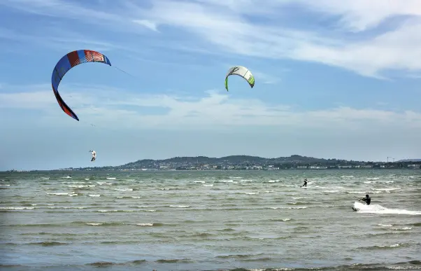  ??  ?? BLUE SKIES: Windsurfer­s enjoy the fine weather on Dublin Bay yesterday. Photo: Tony Gavin