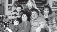  ?? ABC ?? The original cast of Roseanne, seated from left, Michael Fishman, Roseanne Barr and John Goodman, and top row from left, Sara Gilbert, Alicia Goranson and Laurie Metcalf.