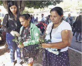  ??  ?? Dolor. Juana de Jesús Realegeño (camisa verde) y María Realegeño (de blanca) recibieron ayer las osamentas de sus familiares asesinados en la guerra.