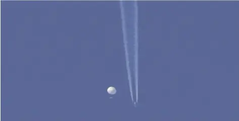  ?? BRIAN BRANCH VIA AP ?? In this photo provided by Brian Branch, a large balloon drifts above the Kingstown, N.C. area, with an airplane and its contrail seen below it.