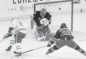  ?? THE ASSOCIATED PRESS ?? New York Rangers goalie Henrik Lundqvist deflects a shot by Montreal Canadiens centre Torrey Mitchell, left.