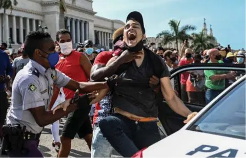  ?? FOTO AFP ?? Duizenden Cubanen kwamen zondag in verschille­nde steden op straat om te protestere­n tegen de voedselsch­aarste en de slechte afhandelin­g van de corona-epidemie op hun eiland