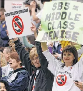  ?? JAY LAPRETE / AP ?? After Gov. John Kasich signed Senate Bill 5 in 2011, which curtailed the collective bargaining rights of more than 350,000 public workers, the group shown here began circulatin­g petitions for a referendum that appeared on the November ballot.