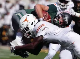  ?? Associated Press ?? Texas defensive back Holton Hill (5) upends Baylor quarterbac­k Charlie Brewer in the first half of an NCAA college football game Saturday in Waco, Texas.