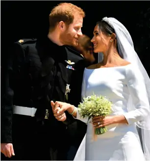  ?? Reuters ?? Britain’s Prince Harry, Duke of Sussex, and wife Meghan, Duchess of Sussex, emerge from the West Door of St George’s Chapel, Windsor Castle, on Saturday after their wedding ceremony. —