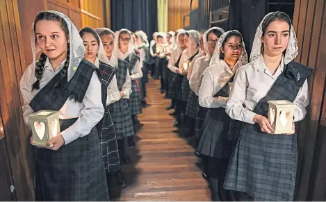  ?? Picture: Getty. ?? Schoolgirl­s from Kilgraston attend the annual Lily Procession in the chapel at the Bridge of Earn school. The annual event, which features more than 100 girls wearing lace mantillas and carrying lanterns, honours Mary, mother of Jesus, and heralds the Christmas season.
