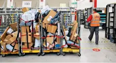  ?? ?? Backlog: trolleys loaded with parcels at Royal Mail‘s sorting office in Chelmsford last year