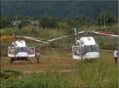  ??  ?? Two helicopter­s wait near the cave for more evacuation­s of the boys and their soccer coach who have been trapped since June 23, in Mae Sai, Chiang Rai province, northern Thailand on Monday.
AP PhoTo/SAkchAI LALIT