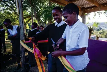  ?? Photo: Atang Matiea ?? Sineliso Bambatha and Alikho Jeyi from the Riebeeck East Combined School cut the ribbon at the unveiling of the first of two eco-benches in Riebeeck East recently.