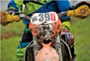  ??  ?? Troy Desimone’s bike is coated with mud before competing.