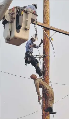  ??  ?? Lansdale Electric lineman Jeff Horvath, on pole, and Foreman Joe Gaburon in bucket train with “Randy,” a dummy meant to simulate a human having an emergency. PHOTO COURTESY OF LANSDALE ELECTRIC