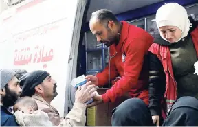  ??  ?? Members of the Syrian Red Crescent distributi­ng medicines for civilians in Douma, eastern Ghouta, a suburb of Damascus, Syria, on Monday.