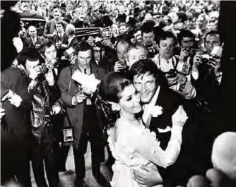  ??  ?? British actor Roger Moore and his new wife Italian actress Luisa Mattioli, are surrounded by the press as they dance at Caxton Hall in London following their wedding on April 12, 1969. — AP/AFP photos