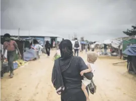  ?? Picture: AFP ?? LONG ROAD. A Rohingya Muslim refugee carries a child through Kutupalong refugee camp in Bangladesh yesterday. The UN has drawn up a contingenc­y plan to feed up to 700 000 refugees.