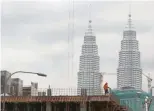  ?? — Reuters ?? A worker is seen at a constructi­on site, with the Malaysia's landmark Petronas Twin Towers in the background, in Kuala Lumpur.